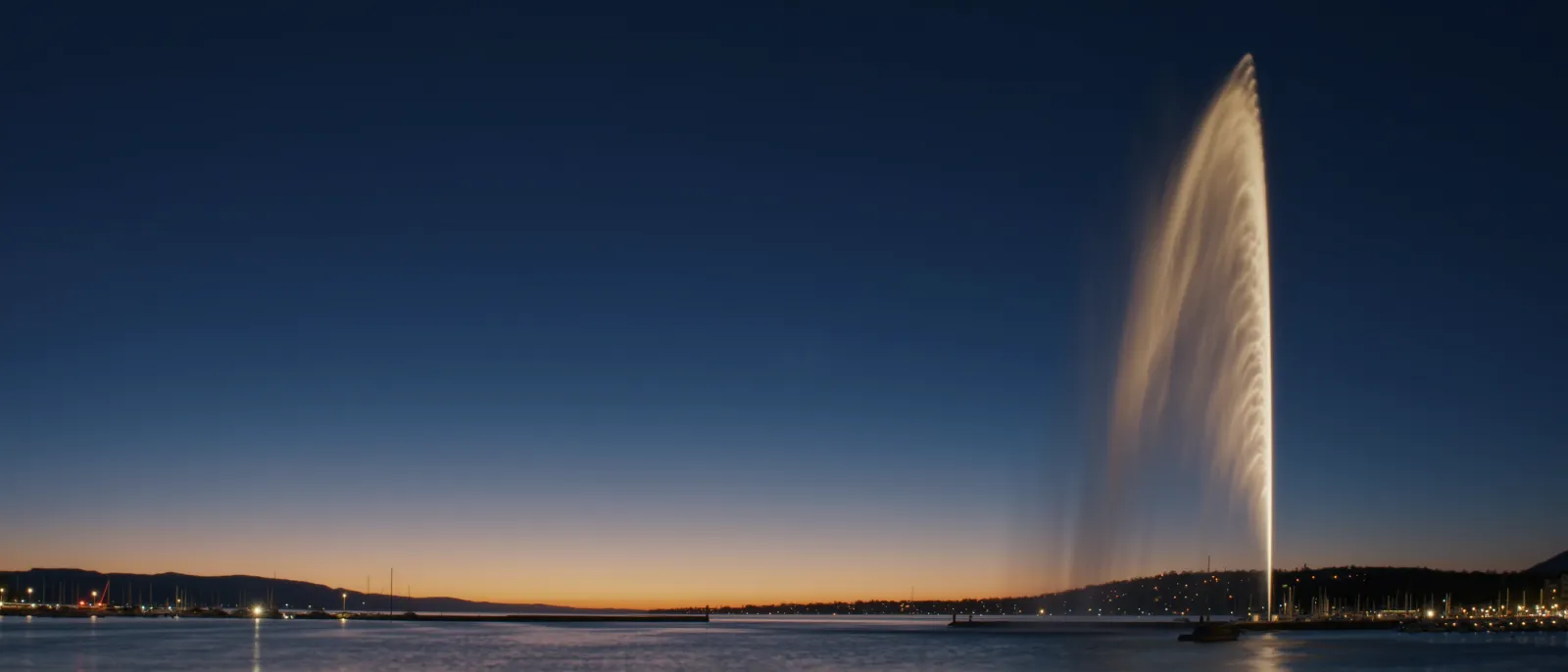La rade de Genève à l'heure bleue, le Jet d'eau éclairé.